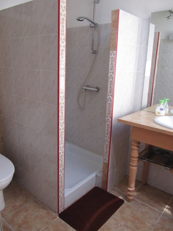 salle de bain rose avec meuble en bois ancien