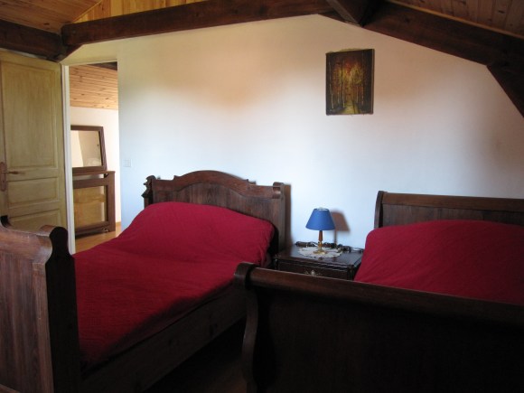 chambre avec lit en bois foncé et dessus de lit rouge