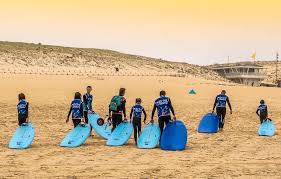 groupe avec des planches de surf bleues sur le sable de la plage de moliets 