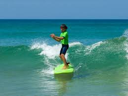 enfant en train de surfer sur une planche de naturashop à leon près de l'annexe