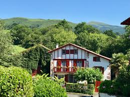 maison typique du pays basque avec colonnade rouge et facade blanche
