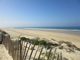 chemin de sable menant à la plage avec l'ocean bleu dans les landes pres de l'annexe